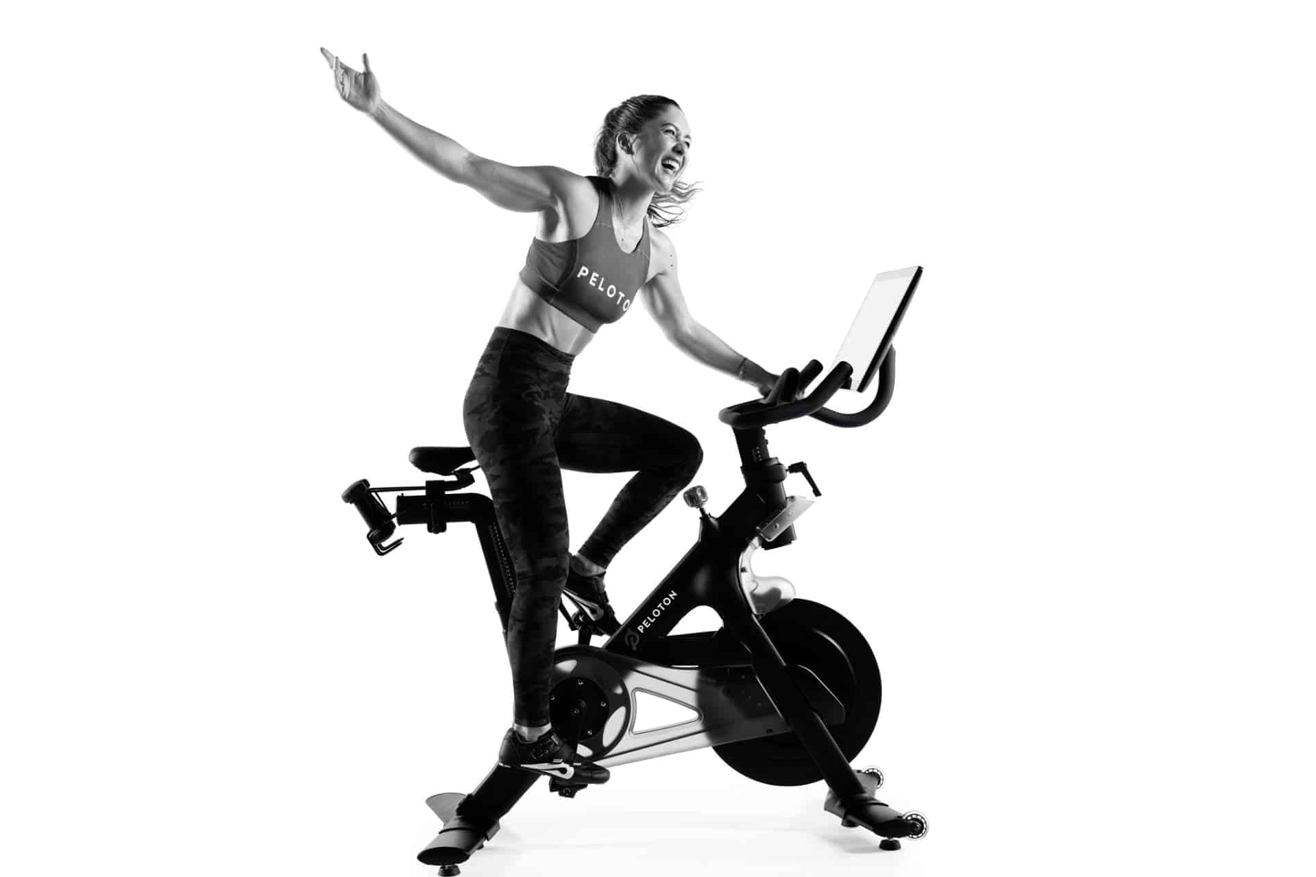 Emma Lovewell, Peloton instructor posing and laughing on a Peloton Bike