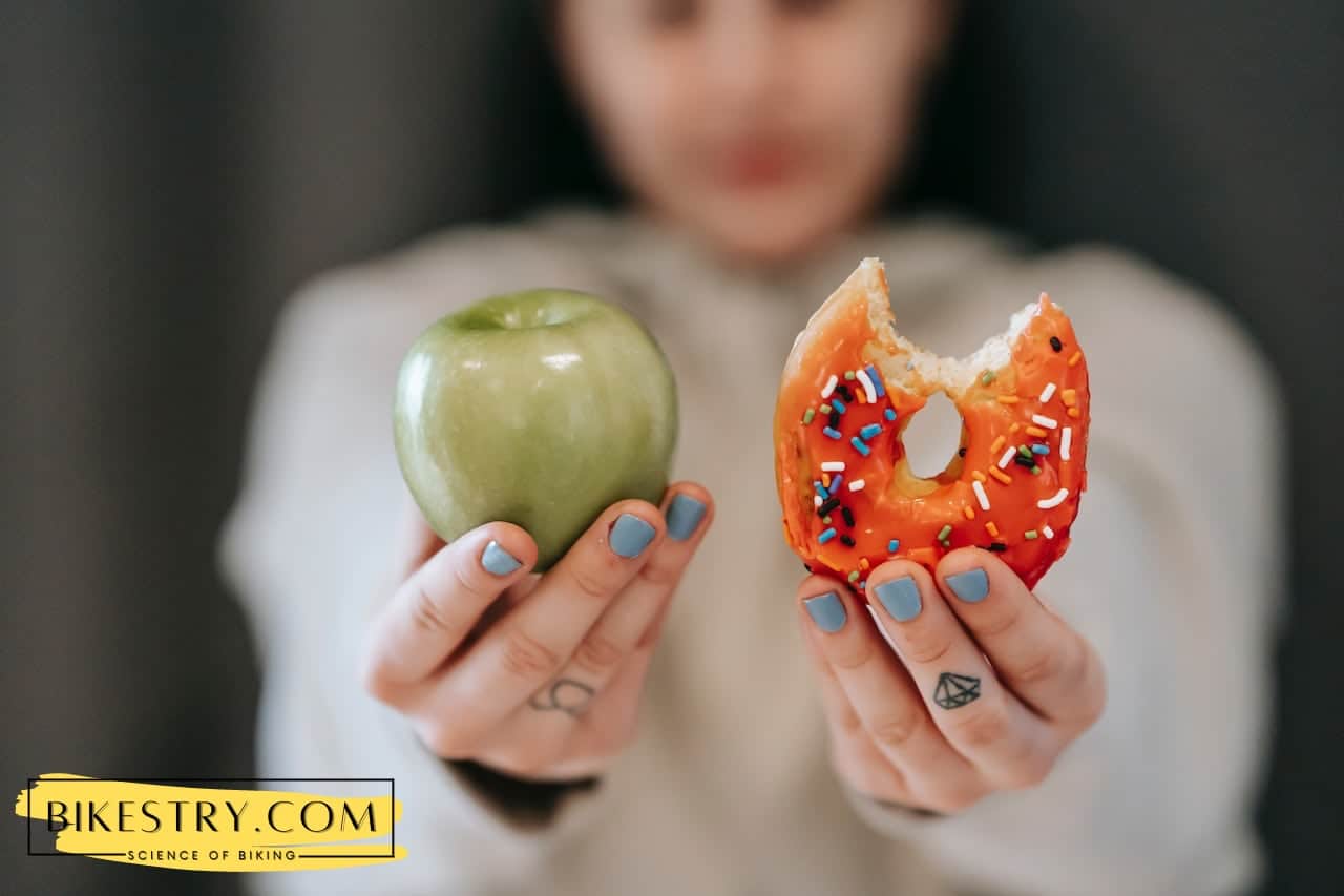 Woman showing apple and bitten donut make your choice